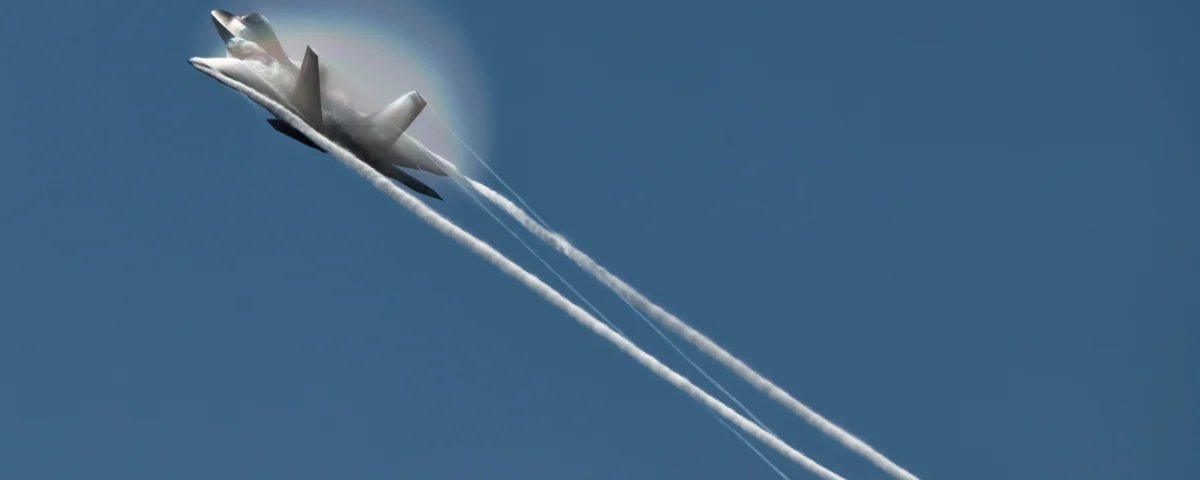 The F-22 generates vapor and a rainbow at NAS Oceana.