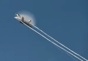 The F-22 generates vapor and a rainbow at NAS Oceana.